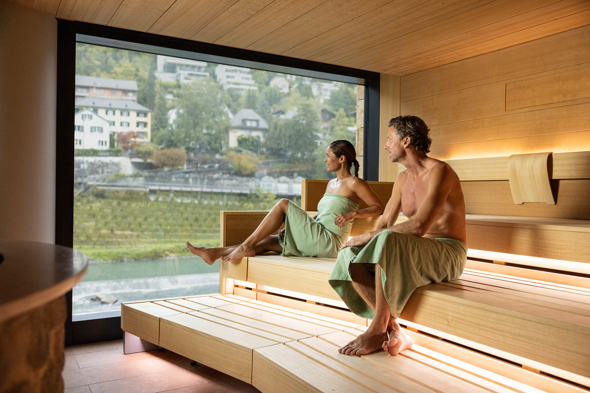 Corporate Branding Bildwelt für das Fortyseven, der Therme in Baden. Ein Paar sitzt in der Sauna mit Blick auf die Limmat.