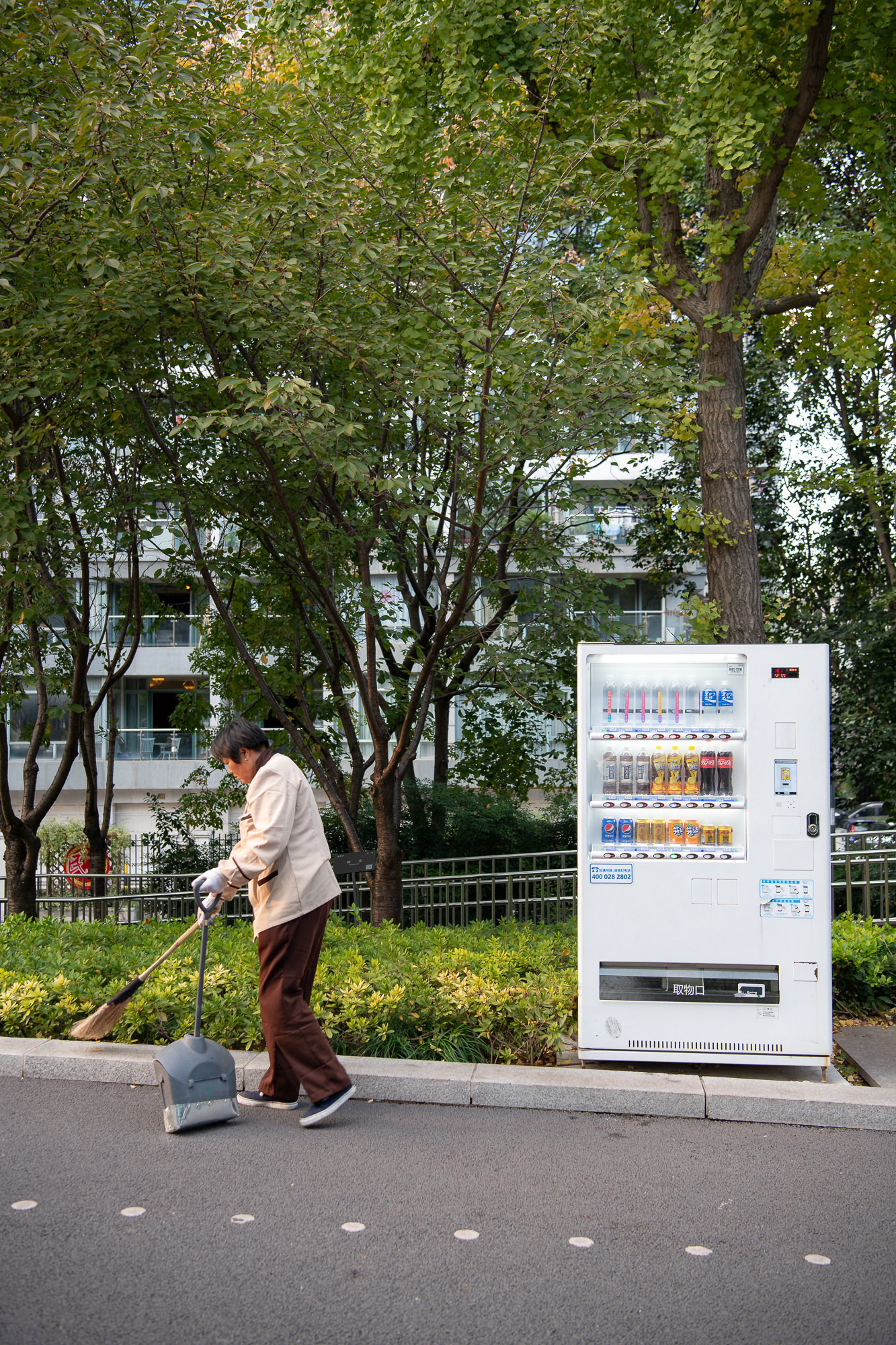 Aufnahme einer Frau beim Strasse fegen. Reportage und Buchprojekt über den Huangpu River in Shanghai, China.