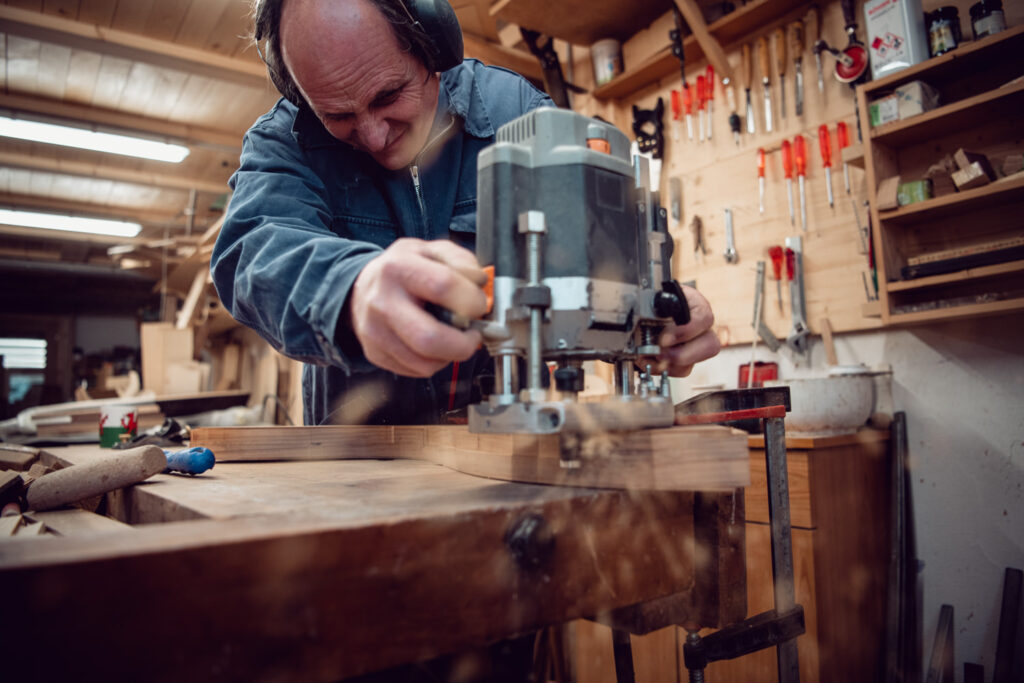 Der Harfenbauer Christoph Mani schleift ein Stück Holz für den Bau einer neuen Harfe.