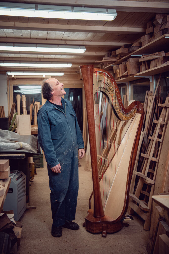 Environmental Portrait für das Landliebe Magazin. Der Harfenbauer Christoph posiert neben einer Harfe.