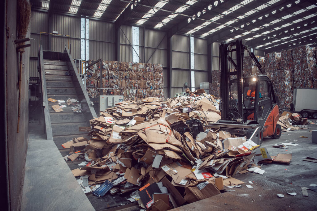 Aufnahme von Altpapier in einer Lagerhalle für das Corporate Branding von Thommen Recycling. Ein Gabelstapler bei der Beförderung von Karton.