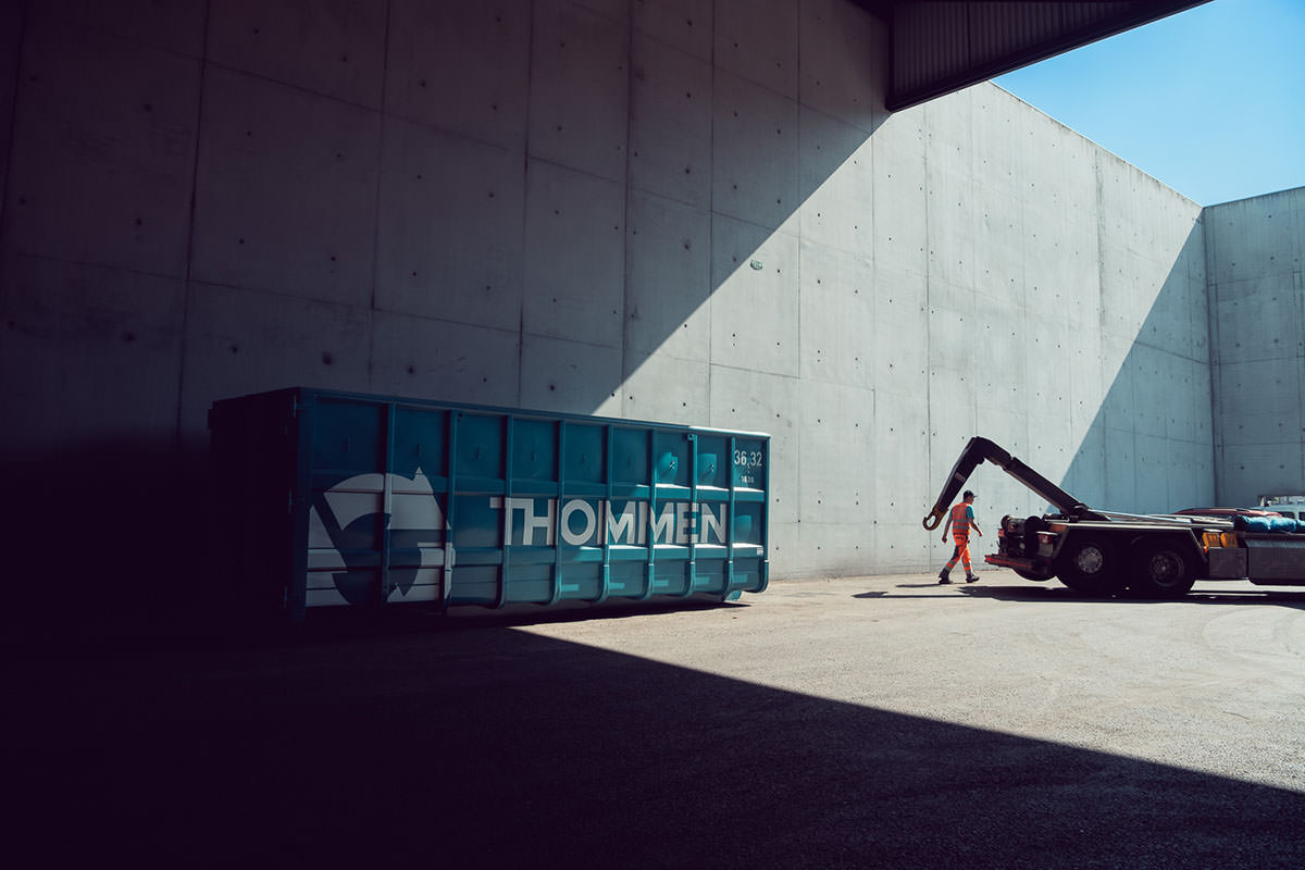Fotografisches Storytelling für Thommen Recycling. Ein Mitarbeiter verlädt einen Container.