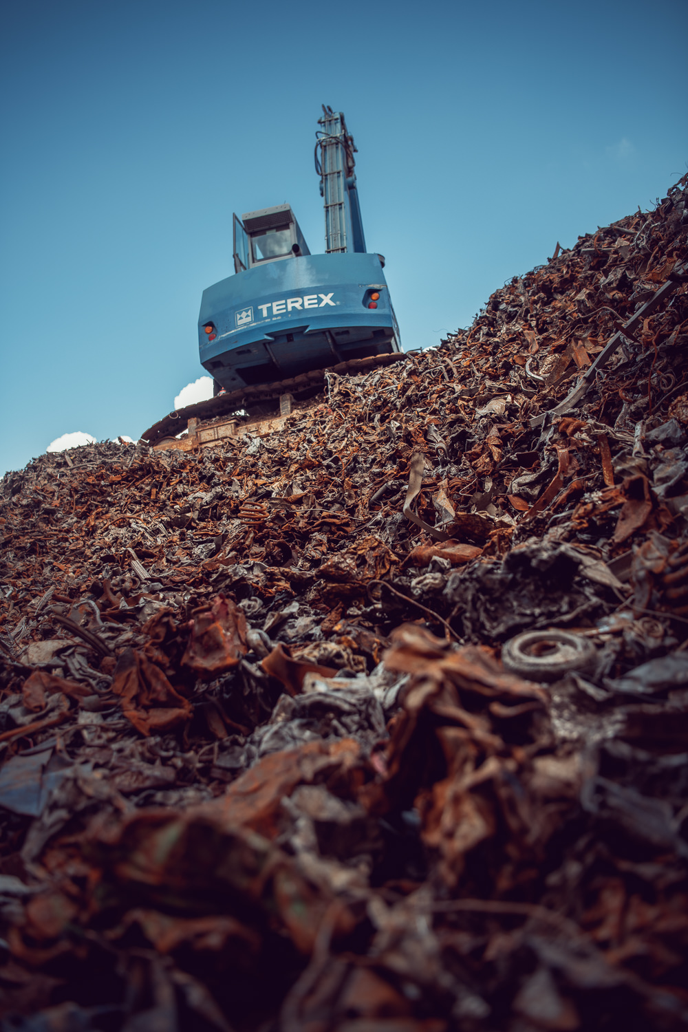 Fotografisches Storytelling für das grösste Recyclingunternehmen der Schweiz. Aufnahme von einem Kran auf einem Haufen Altmetall.