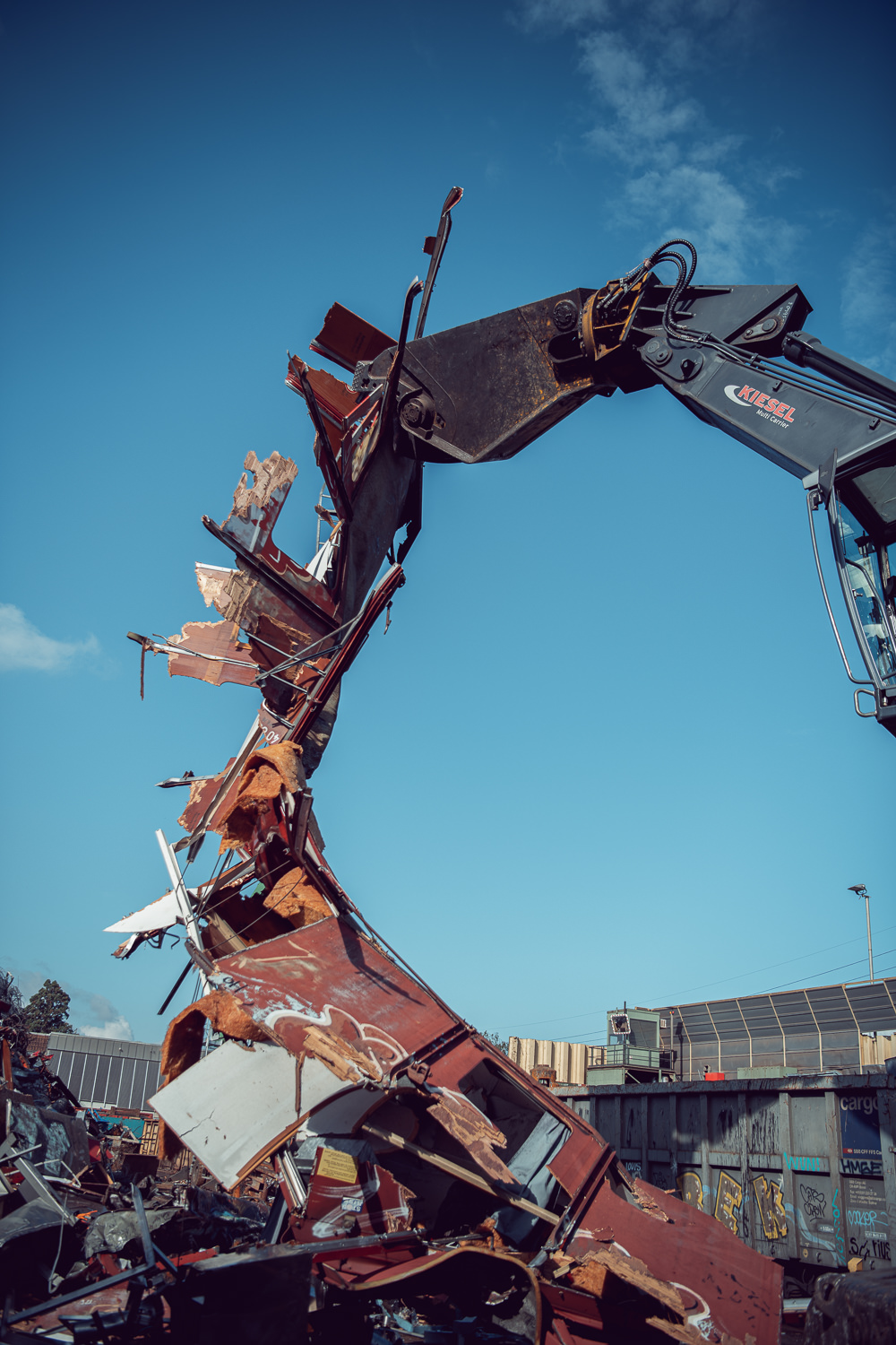 Fotografisches Storytelling für das Recyclingunternehmen Thommen. Aufnahme von einem Kran der ein Zugwaggon zerlegt.