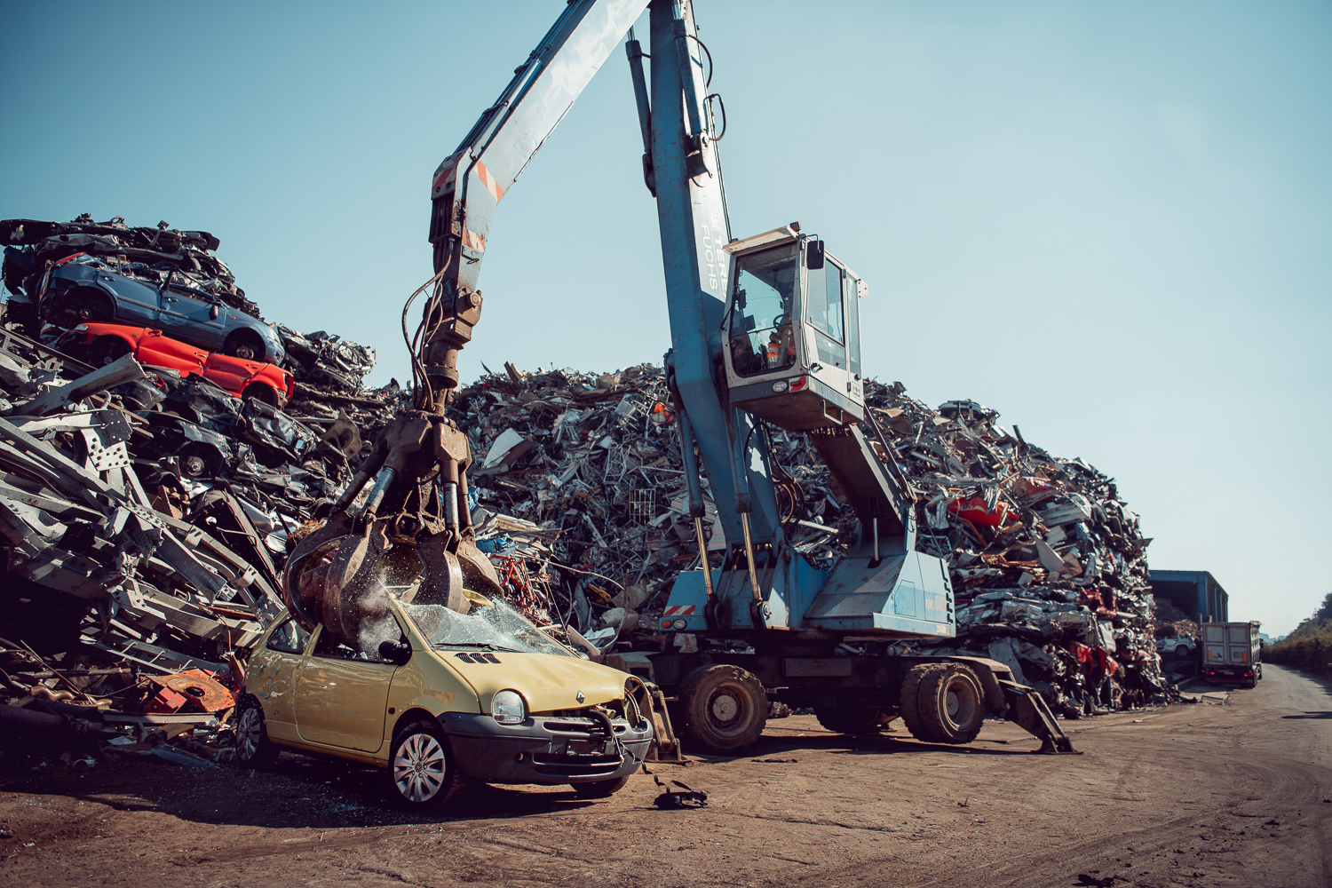 Fotografische Firmenreportage für Thommen Recycling. Aufnahme von einem Kran der ein Auto zur Wiederverwertung zerlegt.